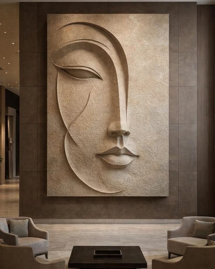 Large textured wall relief of a stylised face in a hotel lounge