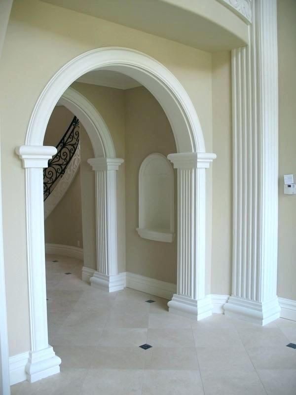 White archway with fluted columns in an entrance hall